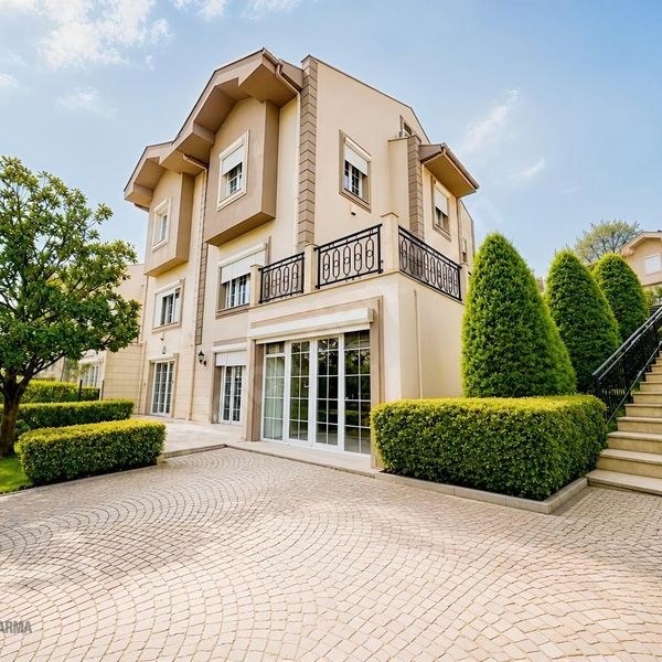 Petekkent Sitesi'nde bahçeli villanın cephesi; taş döşeli giriş, budanmış çitler ve merdiven